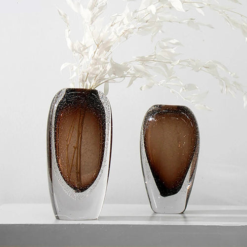 Two decorative vases with a brown and silver design on a white surface.