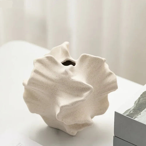 White ceramic vase with textured surface on a light background